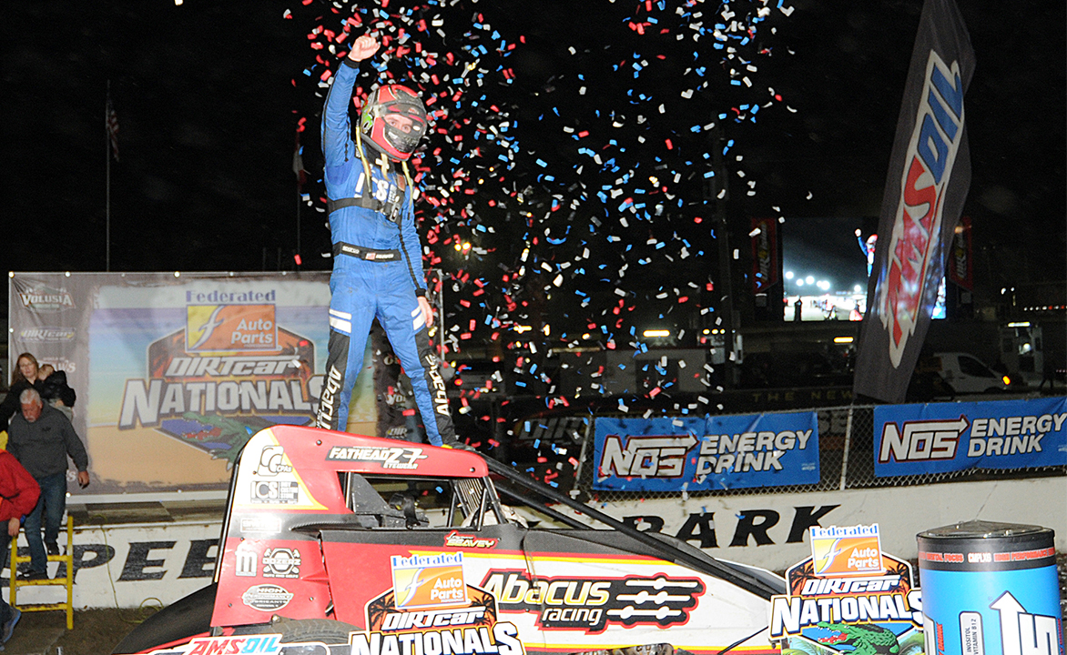 Logan Seavey celebrates with a cage stand atop the Abacus Racing #57